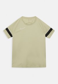 Jasnooliwkowa koszulka Nike z krótkim rękawem, z czarnym paskiem na r�ękawach i białym logo na klatce piersiowej. Gładka tekstura.
