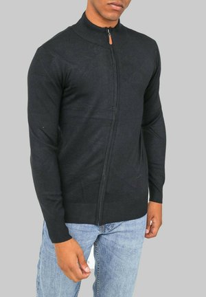 Pull léger zippé noir avec une coupe ajustée, un col haut et des poignets côtelés. Fabriqué en matériau tricoté, il présente une texture lisse et pas de motifs.
