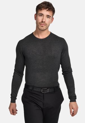 Camicia grigia scura a maniche lunghe e aderente, realizzata in tessuto morbido, con colletto tondo e polsini a coste, abbinata a pantaloni neri e una cintura.