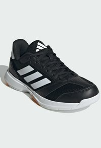 Schwarzer Sportschuh mit atmungsaktivem Mesh-Obermaterial, drei weißen Streifen an der Seite und einer robusten Gummisohle. Strukturierte Oberfläche an der Ferse.