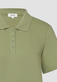 Polo à manches courtes vert olive clair avec quatre boutons et un col, étiquette s.Oliver, taille 36.