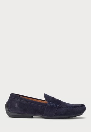 Mocassin pour homme en daim bleu marine avec couture mocassin et semelle en caoutchouc, avec un logo embossé subtil sur le talon.