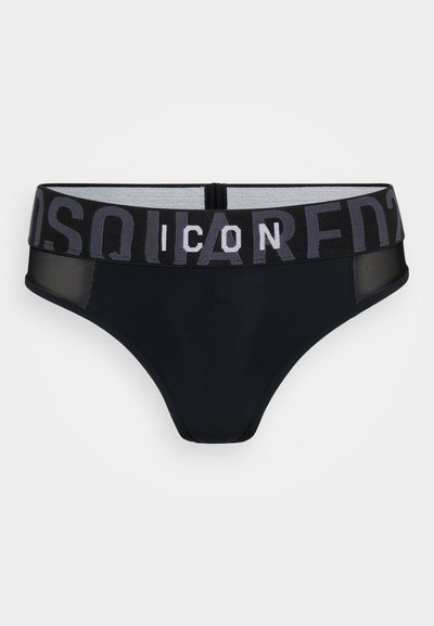 Černé tanga s šedým elastickým pasem, na kterém je nápis „ICON“ tučným písmem. Hladká látka s poloprůhlednými bočními panely.