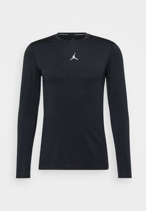Black long-sleeve athletic shirt with a round neck and a small white Jumpman logo centered on the chest.