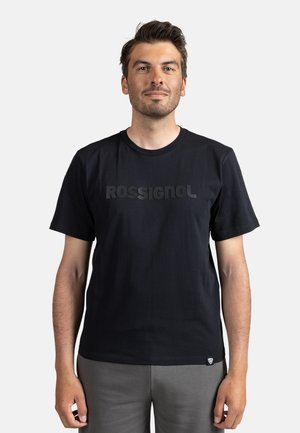 Zwarte katoenen T-shirt met een groot, mat zwart "ROSSIGNOL" logo over de borst. Ronde halslijn en korte mouwen, met een klein logo label aan de onderkant.