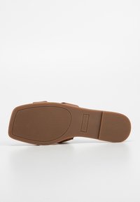 Semelle de sandale marron avec une accroche texturée, forme carrée à l'avant, et "Call It Spring" embossé sur la semelle intermédiaire.