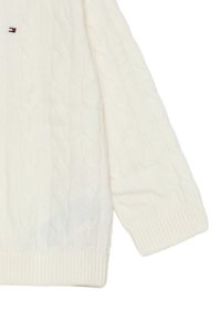 Maglione bianco a treccia con polsini e orlo a coste. Piccolo logo del marchio sul lato sinistro del petto. Texture morbida in misto lana.