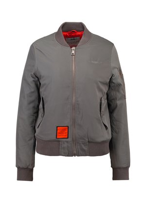 Grijze bomberjack van gladde stof, met ribgebreide manchetten en zoom, een rits aan de voorkant en een oranje label aan de linkerkant. Gevoerd met rood.