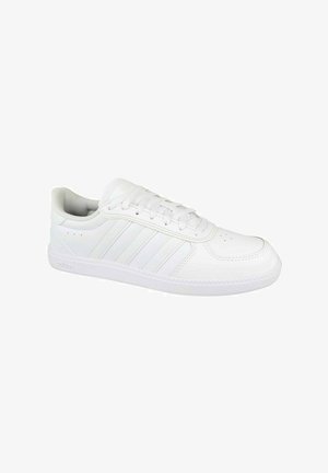 Zapatilla deportiva blanca con material de piel suave, punta redonda, seis agujeros para cordones y tres franjas laterales. Suela de goma gruesa con borde texturizado.