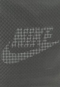 Svart textil med en pixelerad vit Nike-logotypdesign och ett rutmönster som skapar en strukturerad look.