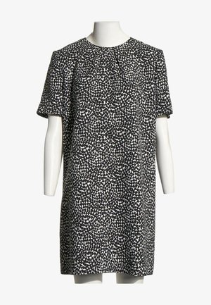 Robe droite à manches courtes noire et blanche avec un motif de points irréguliers sur un buste et des bras de mannequin blanc.