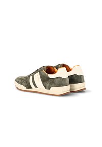 Un par de zapatillas de ante en verde oliva y beige con franjas blancas, forro interior naranja y suelas de goma, vistas desde la parte trasera y lateral.