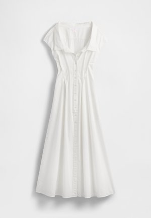 Vit klänning med knappar fram, krage och korta ärmar. Har en vid kjol och vertikala sömmar för formning. Mjuk bomullstyg.