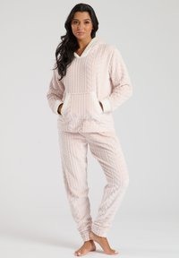 Conjunto de salón rosa claro hecho de una tela suave y texturizada. Presenta una parte superior con capucha y diseño de punto trenzado, junto con pantalones ajustados a juego con puños.