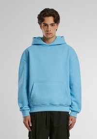 Felpa con cappuccio azzurro chiaro realizzata in morbido misto cotone, con tasca frontale a marsupio, polsini a costine e un taglio rilassato.