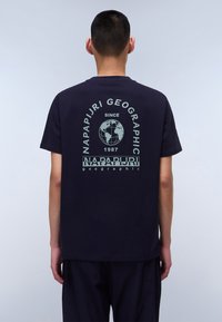 Marineblå bomulds t-shirt med et stort globusgrafik og tekstdesign i lys grøn på bagsiden, korte ærmer og rund hals.