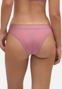 Braguitas de algodón ribeteadas en color rosa con una delicada cinturilla de encaje y un diseño sin costuras, que presentan una textura suave y un corte ajustado.