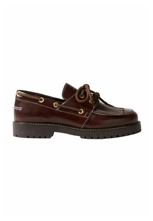 Mocassino in pelle marrone con dettaglio stringato, occhielli dorati, cuciture bianche, frange sulla parte superiore e suola nera spessa e scanalata.