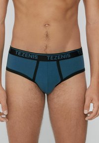 Blaue und schwarze Herrenbriefunterwäsche mit einem schwarzen Bund, der das Logo "TEZENIS" trägt. Der Stoff erscheint glatt und hat minimale Nähdetails.