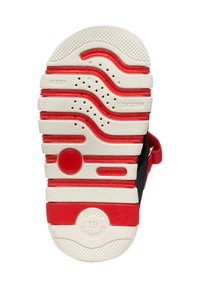 Soletta in gomma rossa e bianca con scanalature per la presa, fori d'aria per la ventilazione e dettagli del marchio. Indicazione di morbida imbottitura.