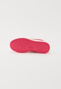 Suela de zapato de goma rosa con superficie texturizada, con un acento circular y líneas diagonales, marcado con "FILA" en letras en relieve.
