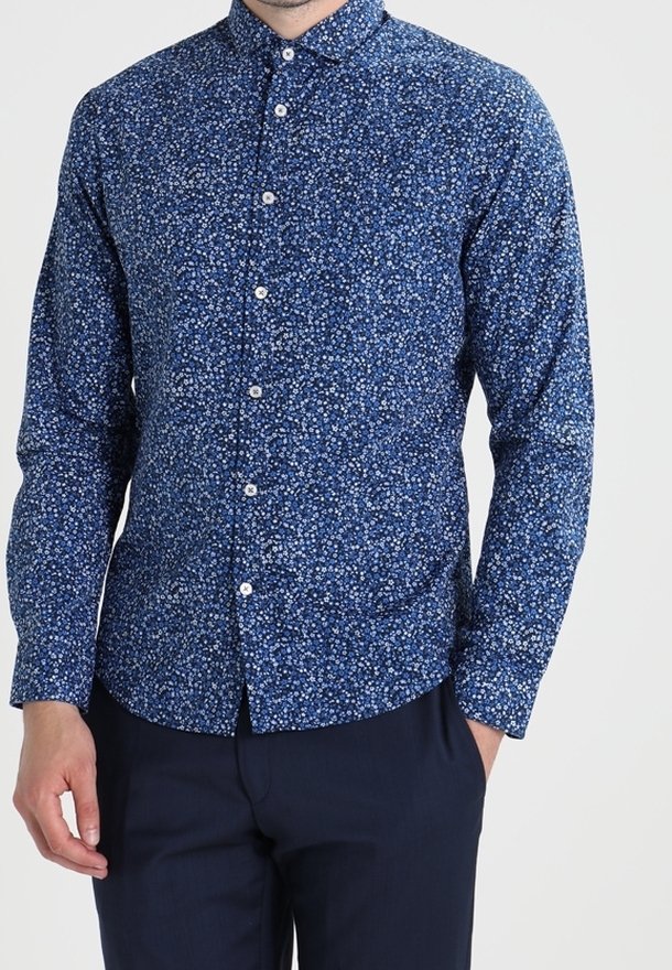 Camicia blu navy con bottoni e un motivo floreale bianco. Presenta un colletto, maniche lunghe e un taglio aderente, realizzata in tessuto leggero.