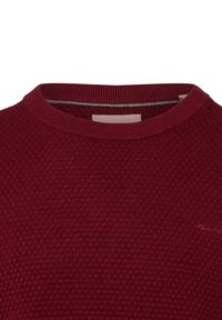 Bordowy sweter o fakturze z okrągłym dekoltem, z splotem w kształcie plastra miodu, prążkowanym dekoltem i minimalnym logo w dolnym prawym rogu.