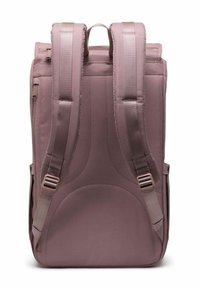 Sac à dos rectangulaire mauve avec des bretelles rembourrées et réglables, une poignée sur le dessus et une poche zippée sur le côté, vu de l'arrière.