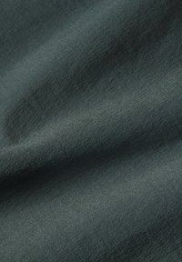 Tela de color verde oscuro con una textura suave y un ligero brillo. El material parece blando y tiene un patrón de tejido sutil y uniforme.