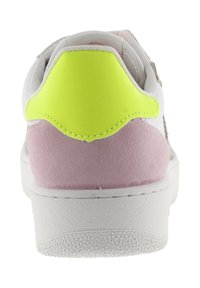 Baskets blanches avec un talon en daim rose et une grande patch jaune à l'arrière, montrées de dos sur un fond blanc.