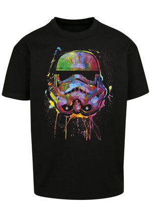 Must must shirt, millel värvitud täpikujuline graafika tormijalgade kiivrist prillidega, näidates elavaid toone ja julgeid kujunduselemente.