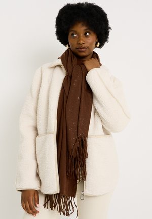 Chaqueta de forro polar crema con dos bolsillos frontales, acompañada de una bufanda marrón con detalles moteados y bordes con flecos.