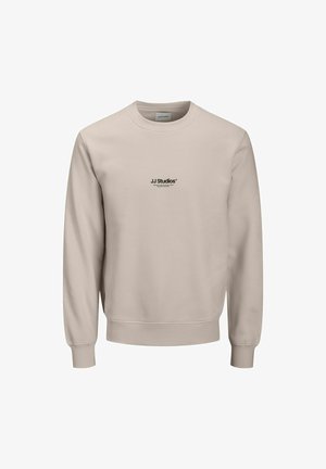 Bež majica s crew izrezom, izdelana iz mehkega materiala, z diskretnim črnim logotipom na prsih ter rebrastimi manšetami in robom.