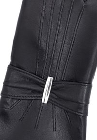 Gant en cuir noir avec un détail en nœud et un accent métallique, des lignes cousues et une texture lisse.