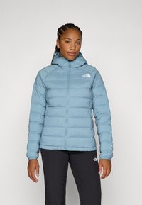Light blue puffy jacket with a hood, featuring a front zipper and ribbed cuffs. The fabric appears smooth with a shiny finish.