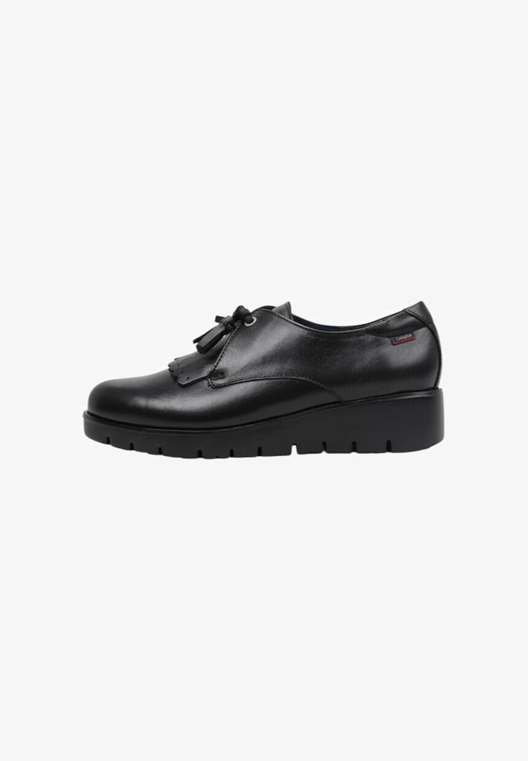 Chaussure en cuir noir avec un bout arrondi, un design à lacets, des franges décoratives et une semelle épaisse et texturée. Rehaussée d'une petite étiquette de marque.