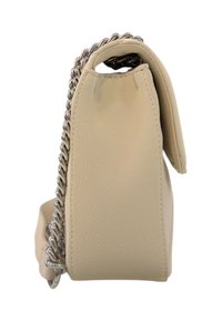 Borsa a mano in pelle beige vista laterale con catena argentata infilata nel manico superiore su sfondo bianco.