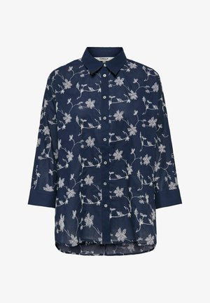 Blouse bleu marine à manches longues avec broderie florale blanche, boutonnage sur le devant, col de chemise et ourlet légèrement arrondi.