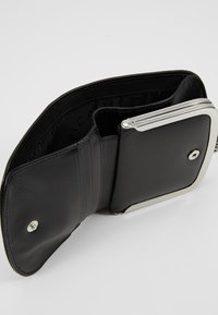 Portefeuille en cuir noir avec un cadre en métal argenté ; l'intérieur comprend des porte-cartes et un compartiment à monnaie, mettant en valeur une texture lisse et un design épuré.