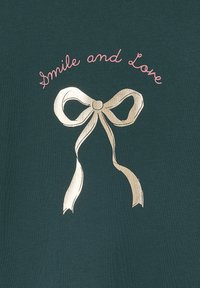 Türkisfarbiges T-Shirt mit goldfarbener Folienbindung und pinkem Text "Smile and Love" darüber. Weiches Material, lässiges Design.