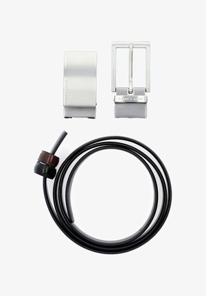 Metalowa klamra i zapięcie w szczotkowanym srebrze, towarzyszące czarnemu skórzanemu sznurowi z drewnianym akcentem, oferujące elegancki design i fakturę.