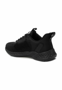 Zapatilla deportiva negra con parte superior de malla, tejido texturizado, bordes redondeados y suela de goma que incluye un collar acolchado y una tira de agarre.