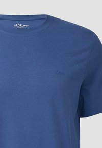 Blaues Baumwoll-T-Shirt mit Rundhalsausschnitt, kurzen Ärmeln und kleinem gesticktem Logo auf der linken Brust. Glatte Textur, schlichtes Design.