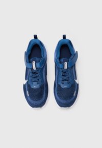 Zapatillas deportivas azules con parte superior de malla, acentos suaves, detalle del logo en blanco, cordones a juego y suela de goma texturizada.