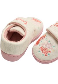 Zapatillas infantiles en rosa y crema con cierre de velcro, tela suave, unicornio bordado y texto "Mágico", y suelas texturizadas para mayor agarre.