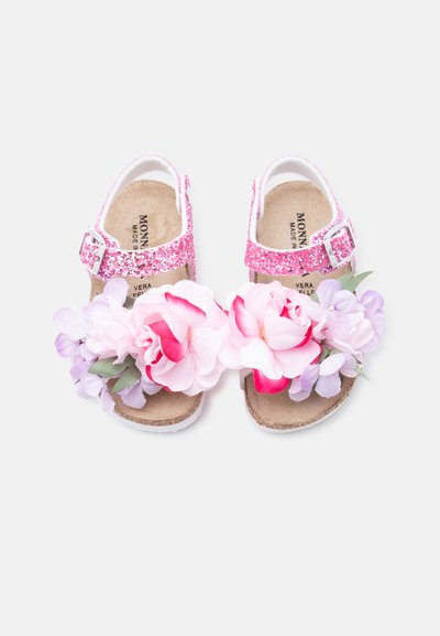 Ροζ σανδάλια με glitter και ρυθμιζόμενες αγκράφες, διακοσμημένα με μεγάλα ροζ και μωβ τεχνητά λουλούδια στα λουριά.