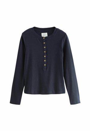 Maglietta henley a maniche lunghe di colore blu navy realizzata in tessuto a coste, con scollatura rotonda e bottoni beige lungo il davanti.