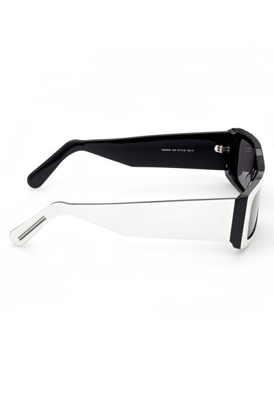 Occhiali da sole con una combinazione di colori in bianco e nero. Montatura rettangolare audace, aste spesse, superficie liscia e lenti scure.