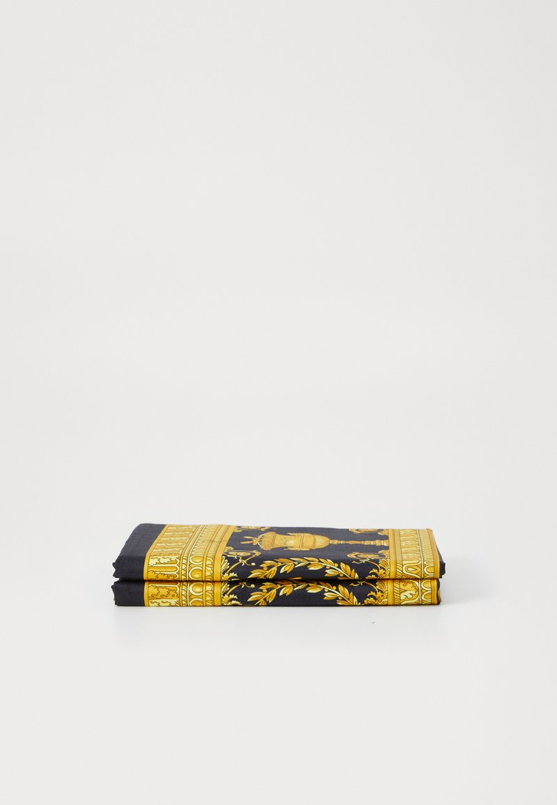 Salocīta melna šalle ar greznām zelta rakstainēm un akcentiem, kurā ir ietverts dizains ar lapām un dekoratīvu urnu. Viegls materiāls.