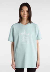 Camiseta de algodón de gran tamaño en azul claro con un gráfico de un conejo de dibujo animado en blanco y la palabra "vans" debajo. Mangas cortas y cuello redondo.